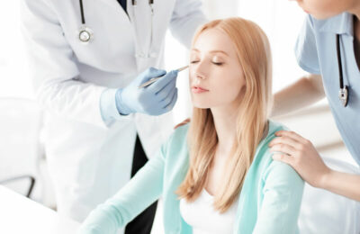 Young woman with closed eyes and two doctors around her.